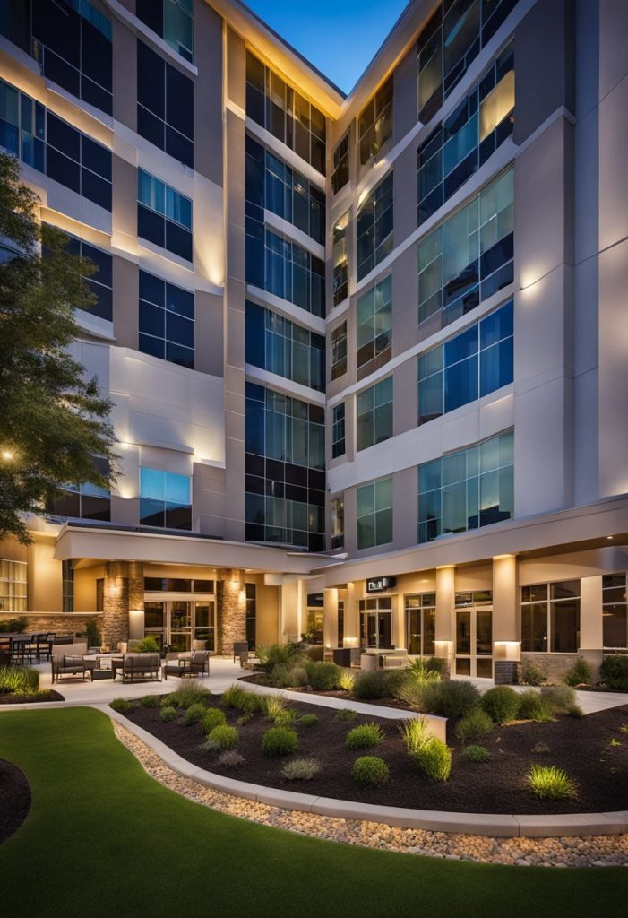 The Hyatt Place Waco is a modern hotel with a sleek exterior and a welcoming entrance. The building is surrounded by well-manicured landscaping, and the warm glow of lights emanates from the windows, creating a cozy and inviting atmosphere