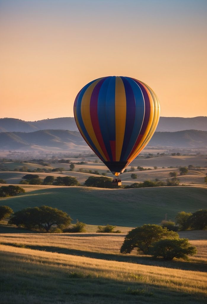 A colorful hot air balloon floats above the Texas countryside, with rolling hills and a bright blue sky ina the background