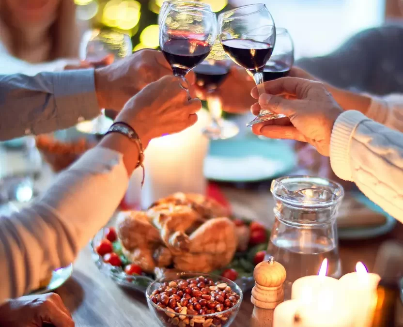 Family and friends dining at home celebrating Christmas Eve with traditional food and decoration, all sitting at the table together making a toast, Where to Eat This Christmas Day in Waco, Texas