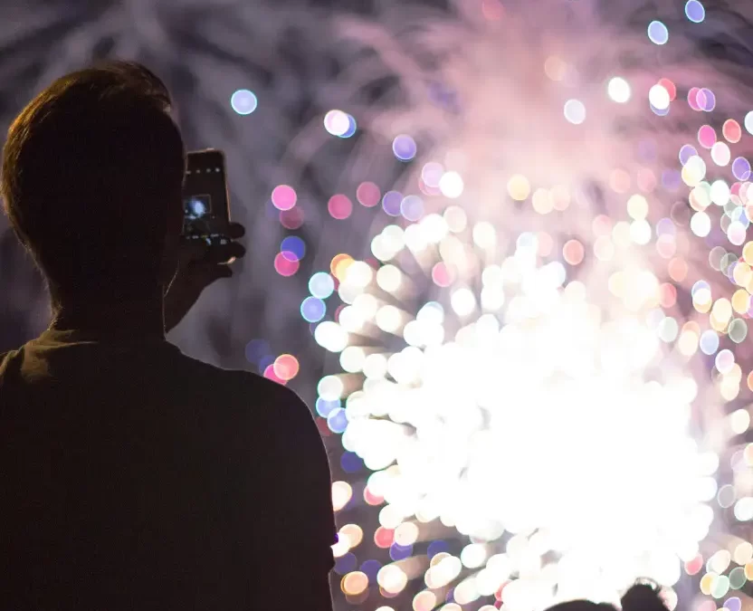 A man recording fireworks while watching fireworks, Top 10 Things to Do in Waco This New Year's Eve 2024.