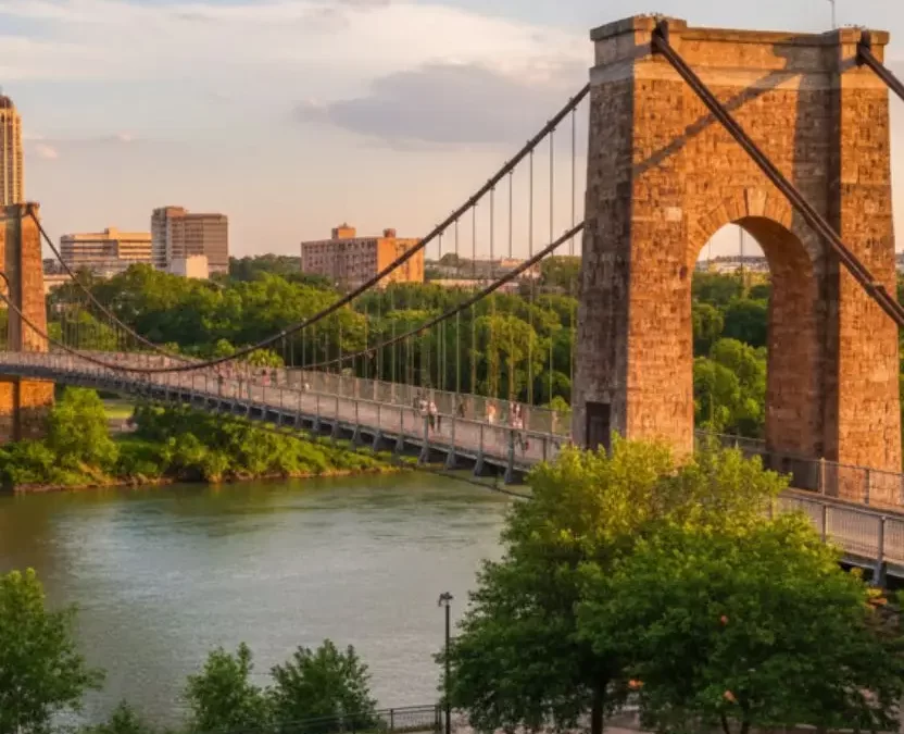 Historic Waco Suspension Bridge over the Brazos River at sunset with people walking on the path