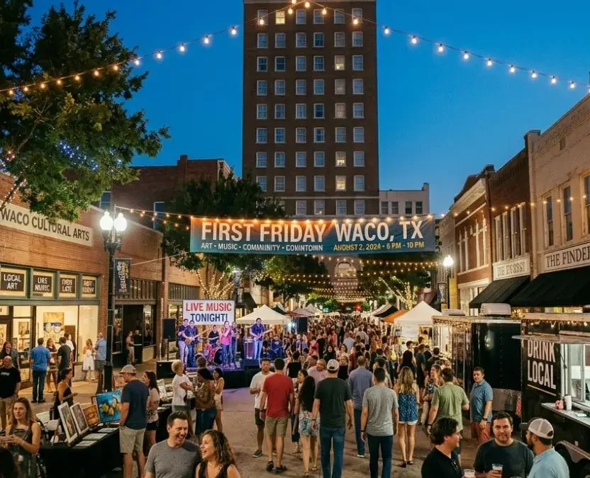 A bustling evening street festival during First Friday in Waco Texas, featuring a vibrant crowd, local food trucks, live music, and the historic ALICO building illuminated under a twilight sky.