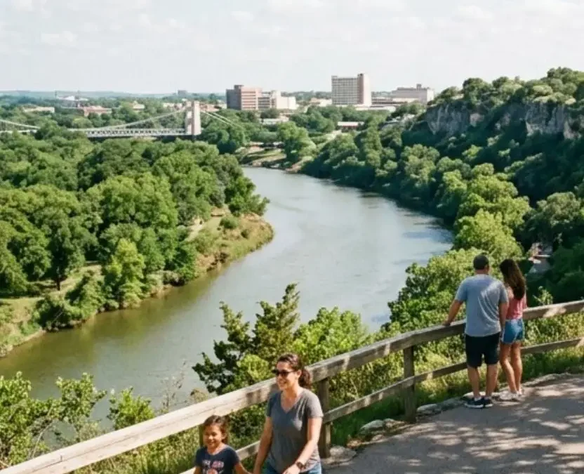 A family walks along a paved trail at Lover's Leap overlooking the river at one of the free parks in Waco Texas.